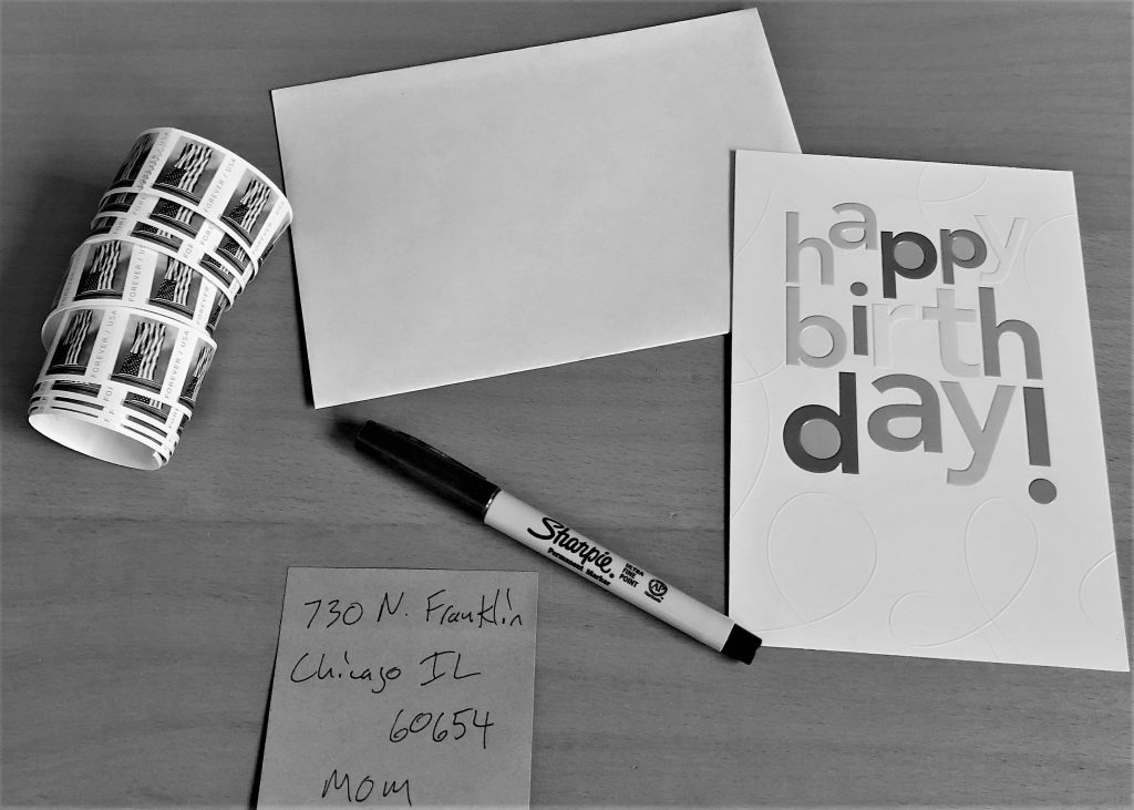 greeting card, envelope, and stamps flat lay