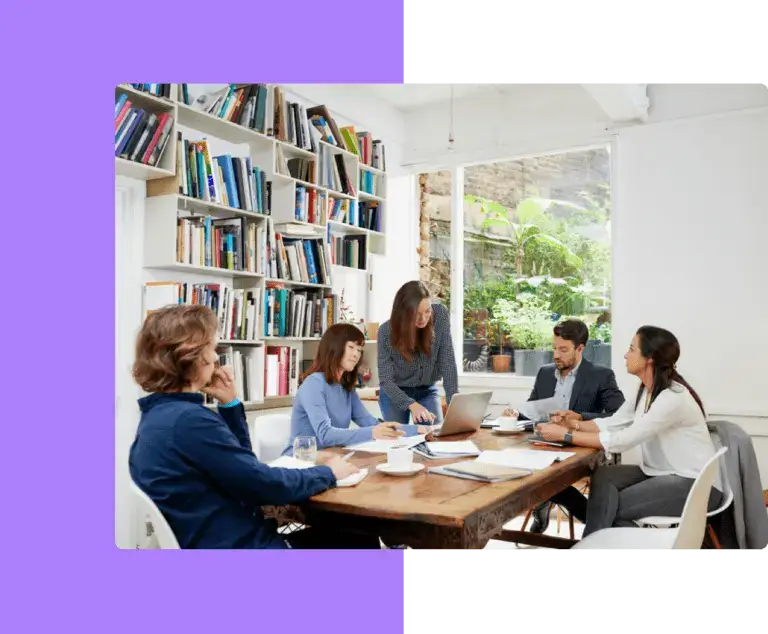 A publishing team in discussion around a table, representing the collaborative and supportive services provided by eMagazines.