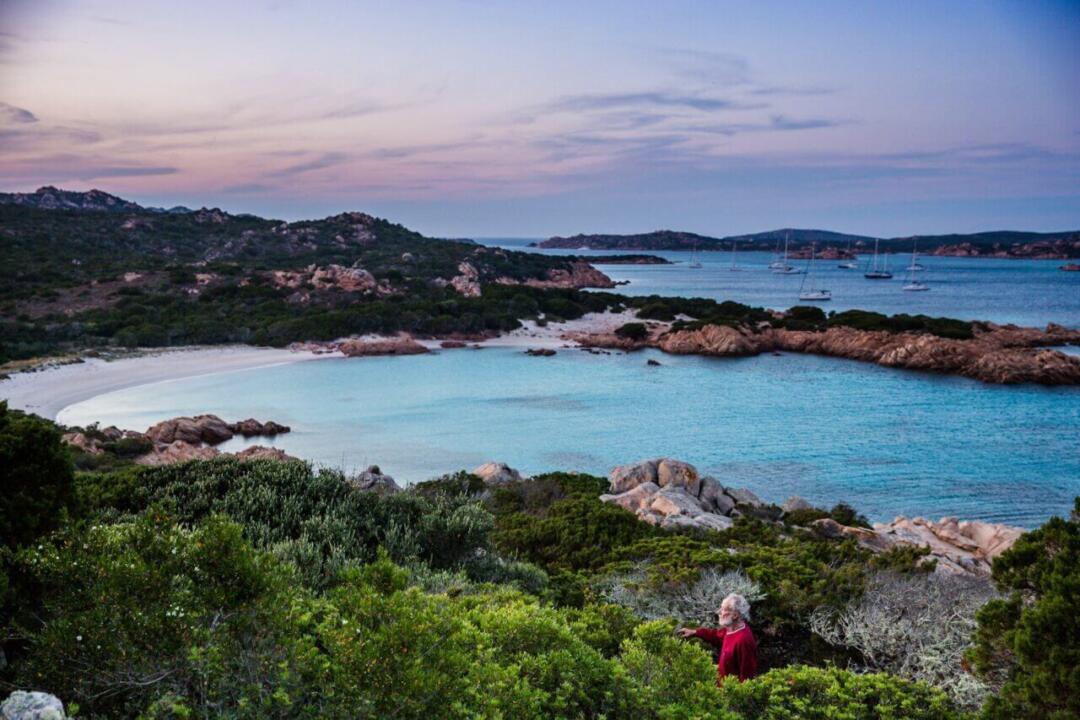 Sardinia's Budelli Island in Italy - hilltop scenic view, ocean in the background and yachts in the distance