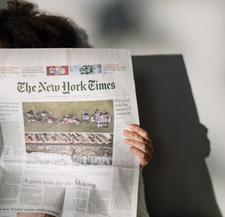 person reading New York Times newspaper